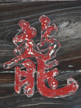 Japon geleneksel kaligrafisinin ahşap tahtadaki kırmızı boyayla yapılmış görüntüsünü kapatın.