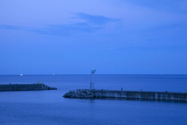 Deniz kıyısında deniz feneriyle güzel gün batımı gökyüzü   