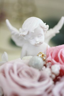 Beyaz melek heykelinin güzel çiçekli yakın görüntüsü.