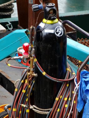 Etrafı renkli hortumlarla çevrili büyük bir dalış tankı.