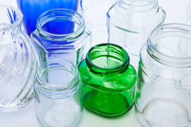 Beyaz arka planda çeşitli boyut ve renklerde cam şişeler.