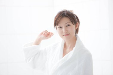 Beyaz bornoz giyen güzel bir Japon kadın.