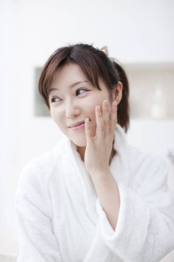 Beyaz bornoz giyen güzel bir Japon kadın.