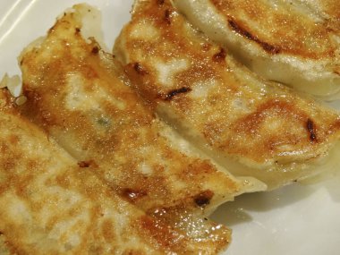 Kızarmış hamur köfteleri beyaz tabakta yakın düzenlenmiş.