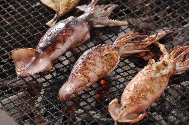 Izgarada pişen gurme deniz ürünlerinin yakın çekim görüntüsü.   