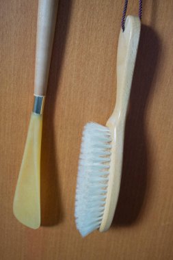 Tahta duvarda asılı iki temizlik aleti.