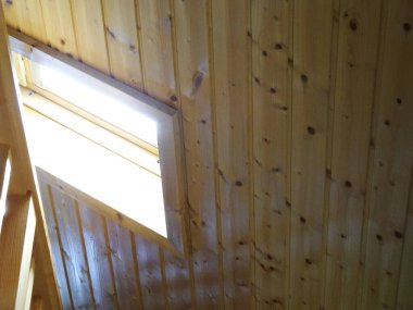 Düşük açılı, açık kahverengi, tahta çatılı bir ev.