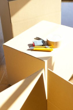 Boş odadaki karton kutudaki araçların yakın görüntüsü. yeni ev kavramı        