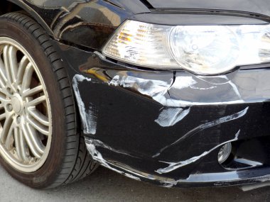 Yakından bakınca hasarlı siyah araba tamponu görünüyor.