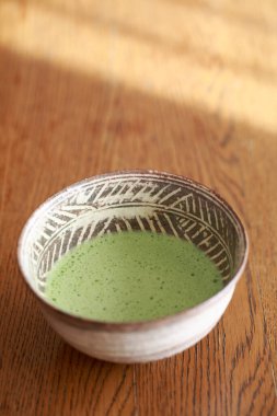 Yeşil sıvıyla dolu seramik kase.