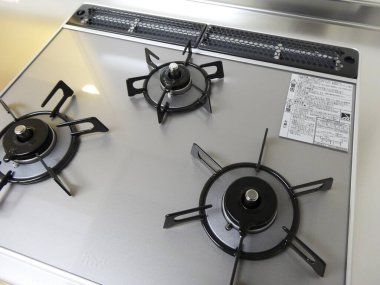 Üç siyah ızgaralı modern paslanmaz çelik gaz ocağı.