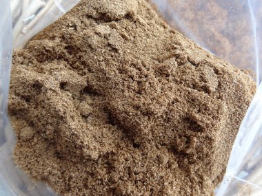 Plastik torba içindeki kahverengi zemin baharatını gösteren yakın plan.