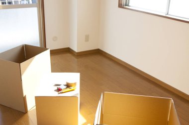 Boş odadaki karton kutudaki araçların yakın görüntüsü. yeni ev kavramı        