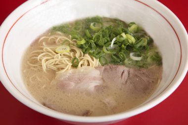 Taze soğan ve domuz eti ile servis edilen lezzetli ramen kasesi.