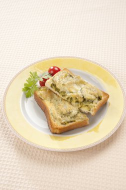 Kızarmış ekmek, erimiş peynir ve otlar.