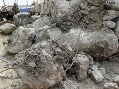 Bükülmüş metal çubukların arasına dağılmış büyük beton enkaz yığınları.