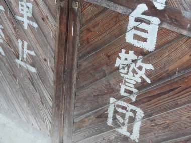 Beyaz Çince harflerle dikey boyanmış tahta kapı.