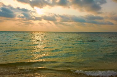 Gün batımı dalgalar ve bulutlarla           