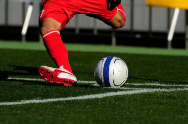 Spor giyim sektöründe futbol oyuncusunun bacakları çimlerin üzerinde top oynuyor.                 