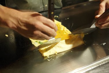 Eller ızgarada omlet hazırlıyor.