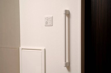 Beyaz buzdolabı kapısı. Koyu kapının yanında dikey sapı var.