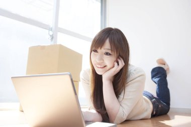 Dizüstü bilgisayarda çalışan genç bir kadın.