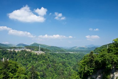 Dağları ve mavi gökyüzü olan güzel bir manzara.