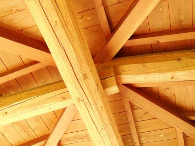 Evin açık kahverengi ahşap çatısının alçak açılı görüntüsü.