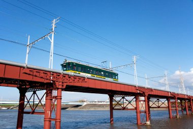 Japonya 'da bir demiryolu köprüsünden geçen tramvay