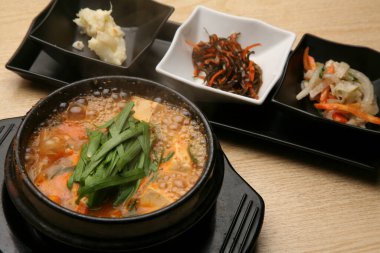 Geleneksel Kore güveci akşam yemeği sırasında bir restoranda garnitürle servis edilir.