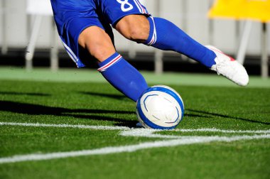 Spor giyim sektöründe futbol oyuncusunun bacakları çimlerin üzerinde top oynuyor.                 