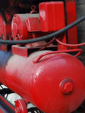 Kırmızı endüstriyel hava kompresörü açık havada görünüyor.