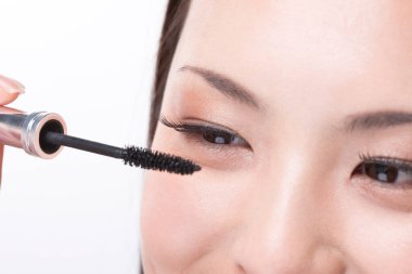 Maskara süren genç Asyalı kadın.