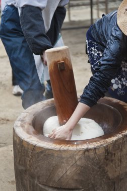 İnsanlar geleneksel mochi yapıyorlar. Tahta tokmak kullanıyorlar.