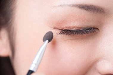 Yüzüne makyaj yapan bir kadının portresi. 