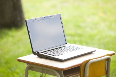 Laptopu yeşil alandaki açık masada kapat.