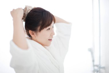 Beyaz bornoz giyen güzel bir Japon kadın.