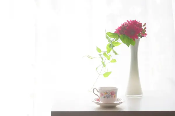 cup of tea with flower in a transparent vase