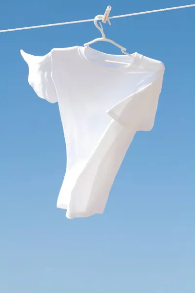 Uma Camisa Branca Pendura Agains Fundo Céu Azul — Fotografia de Stock