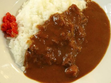 Pirinçli tabak ve körili domuz eti.