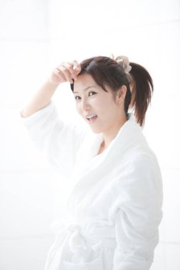 Beyaz bornoz giyen güzel bir Japon kadın.