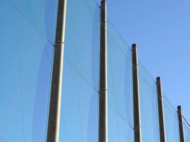Bir dinlenme alanında açık mavi gökyüzü altında spor faaliyetlerini destekleyen ağ yapısı