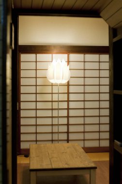 Minimalist Japon odası, ahşap masa ve Shoji ekranları var.