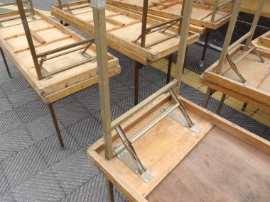 Birkaç ahşap masa kaldırımda baş aşağı duruyor.