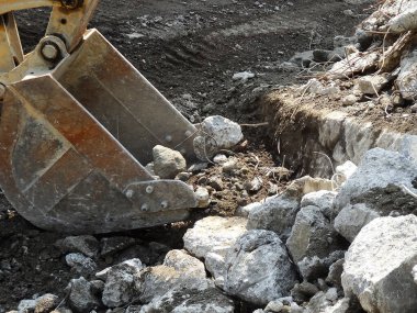 İnşaat alanında taş yığını olan inşaat kazıcısı