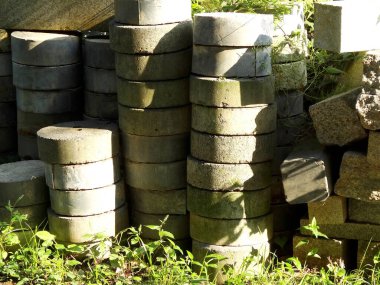 Çimenlerin ve açık havada güneş ışığının arasında beton kaldırımlar yığılıyor.