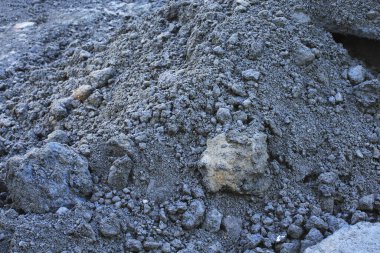 Dağılmış kaya ve çakıl taşlarından oluşan kaba gri çakıl yığını.