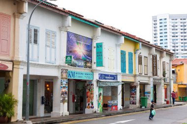 Kapalı pencereli sessiz cadde boyunca uzanan renkli mağazalar