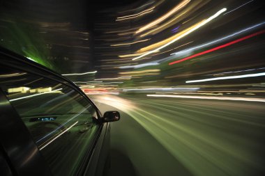 Gece yolundaki arabanın hareket bulanık görüntüsü ve ışık yolları, uzun pozlama 