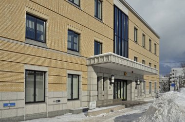 Kış manzarasında kar olan modern bir bina.